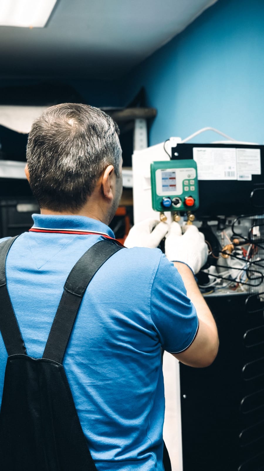 A technician working on an air conditioning system indoors