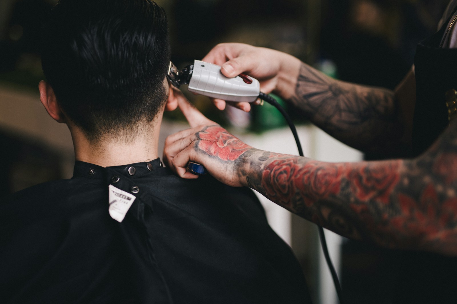 A barber using clippers on a client's neckline