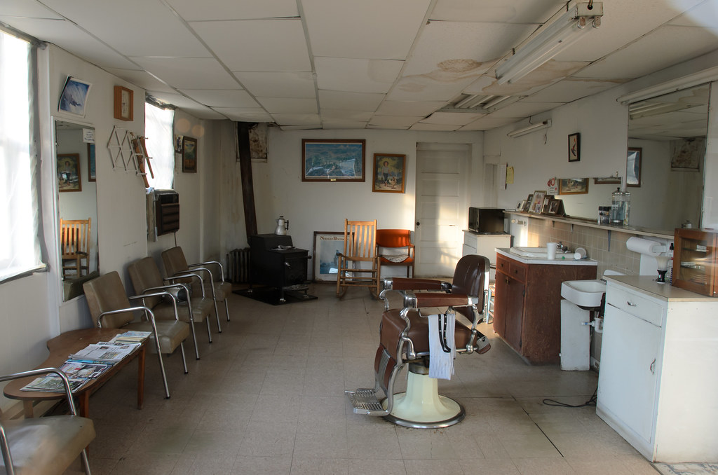 An empty barbershop interior with barber chairs and mirrors