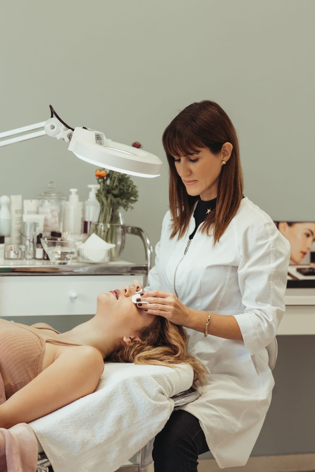 An esthetician performing a skincare procedure on a client in a salon
