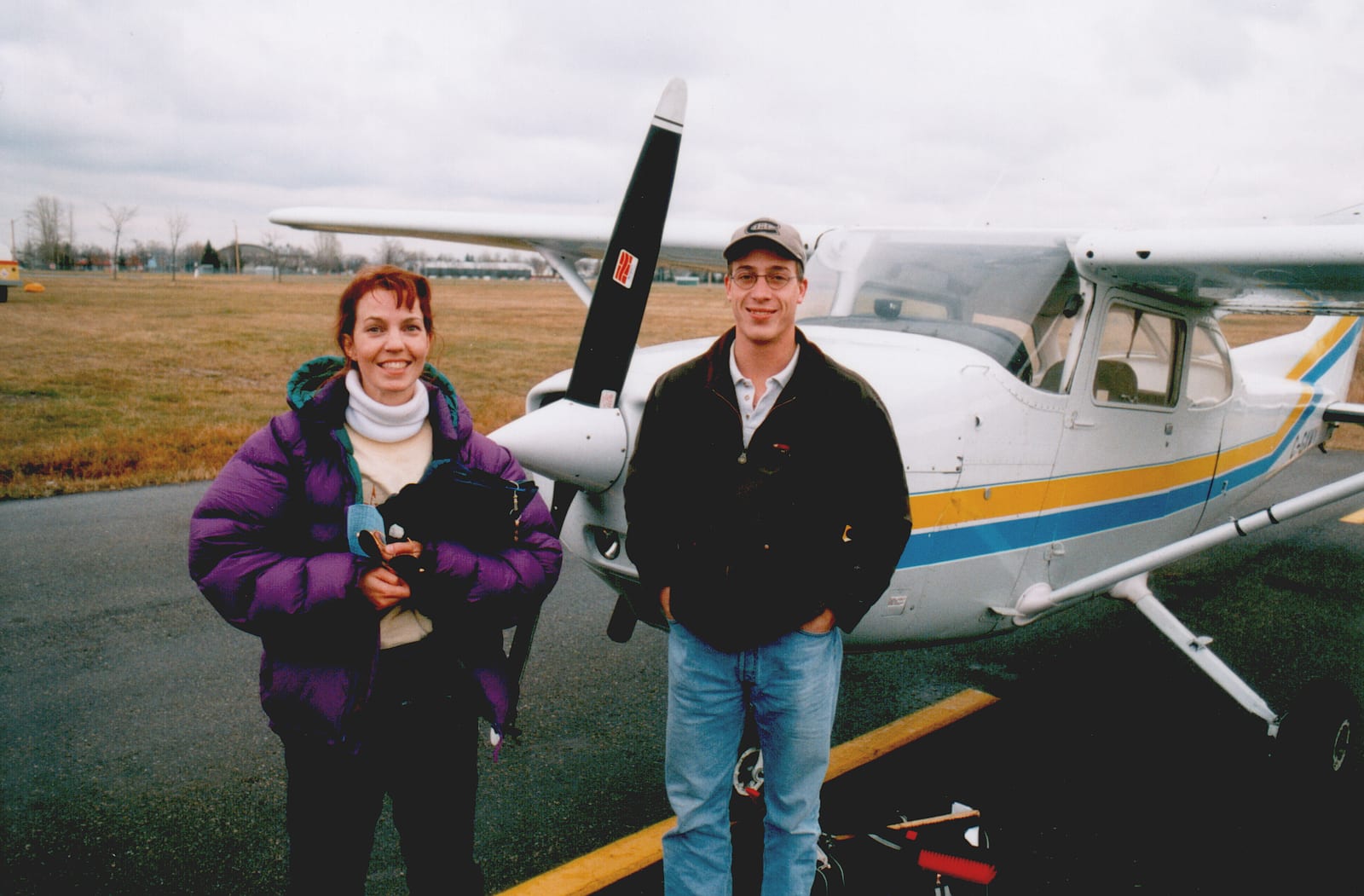A flight instructor and student standing next to a Cessna 172 training aircraft