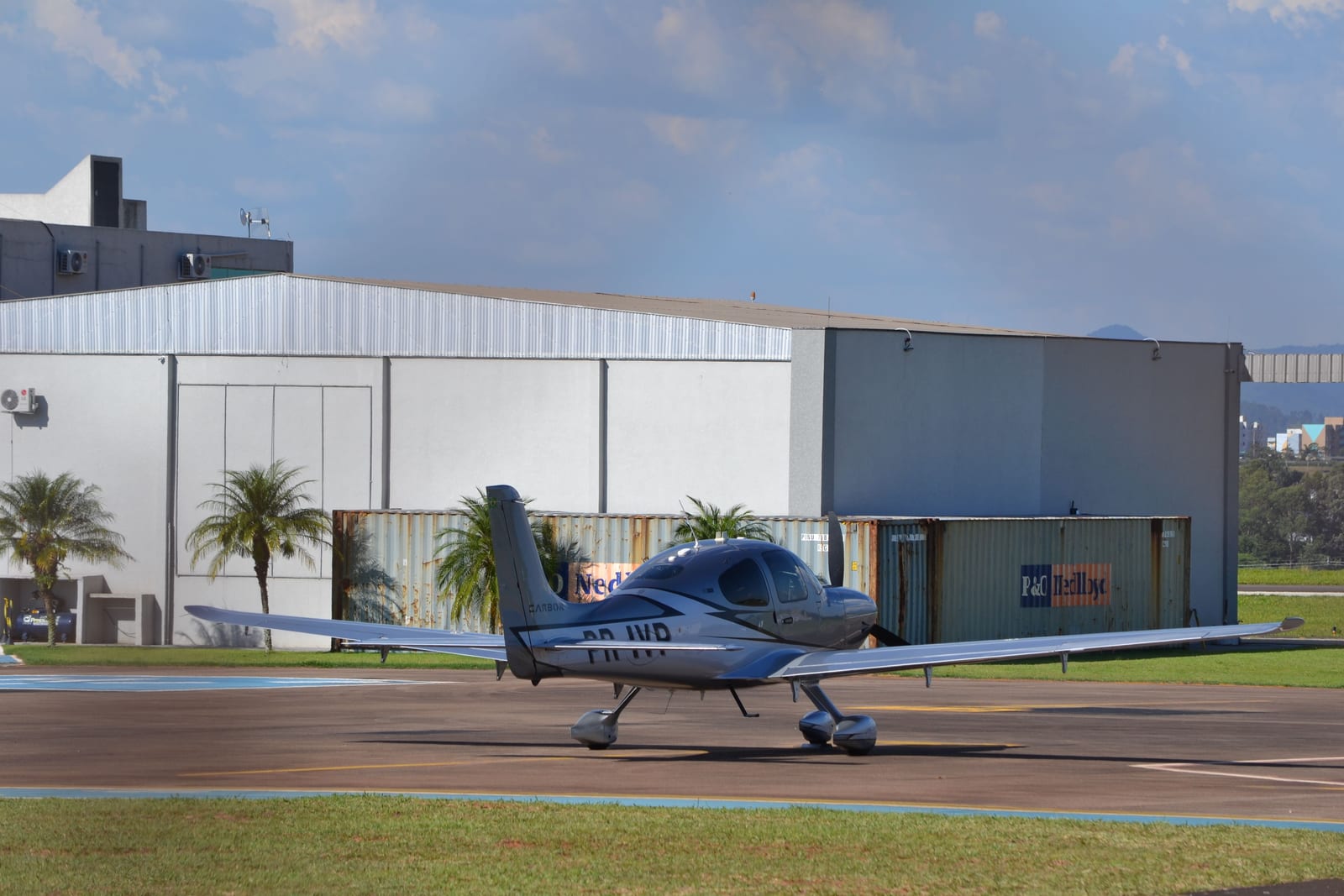 A small private airplane parked on the runway at a small airport