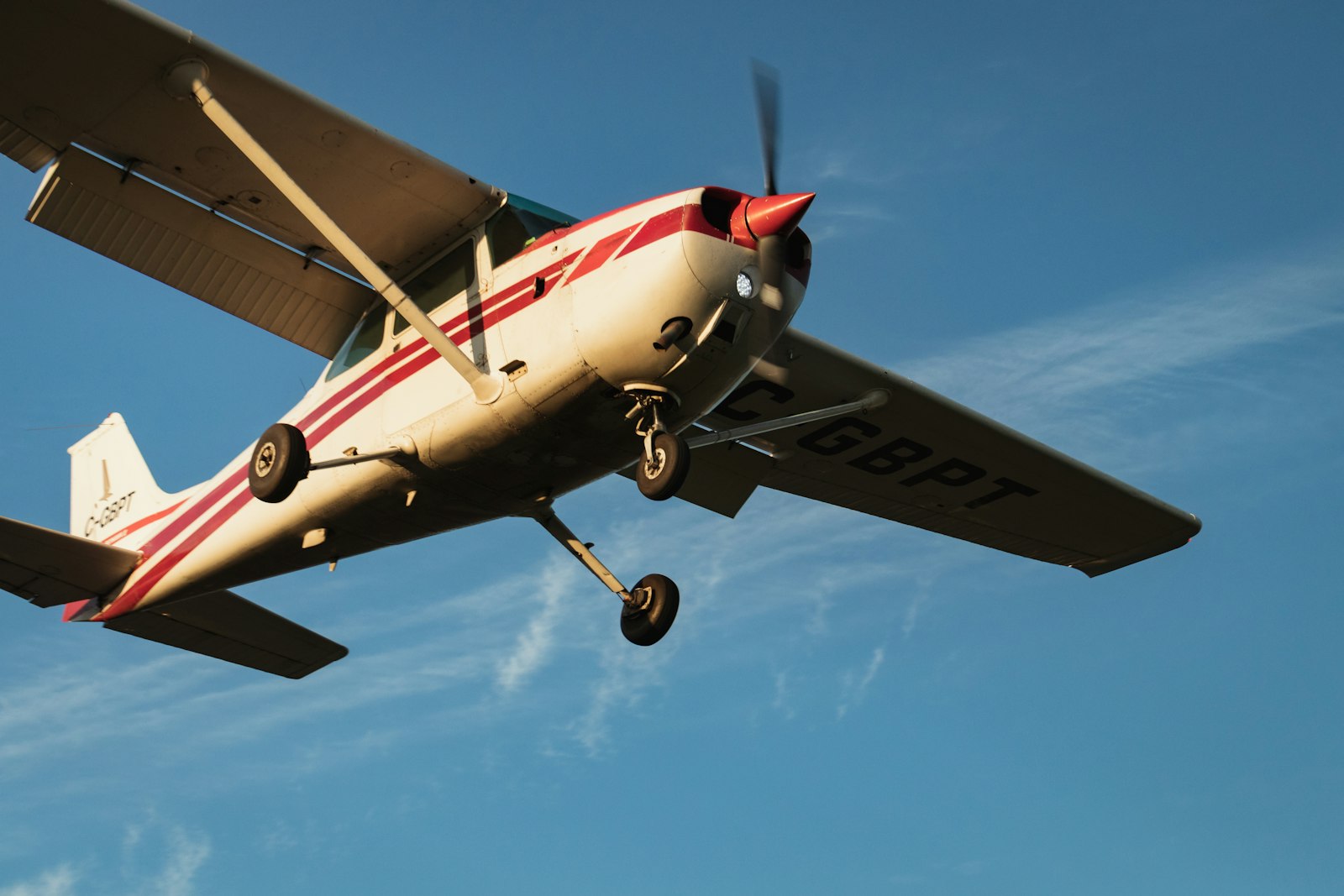 A small single-engine airplane in flight against a blue sky