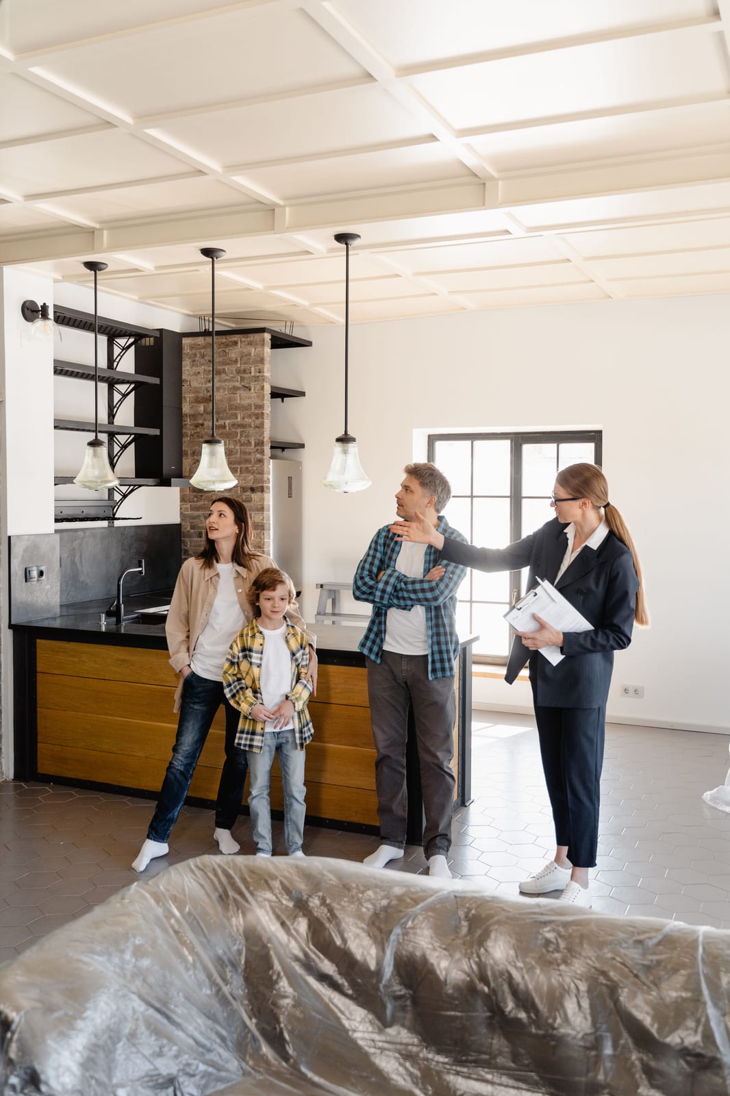 A real estate agent showing a home's kitchen to prospective clients