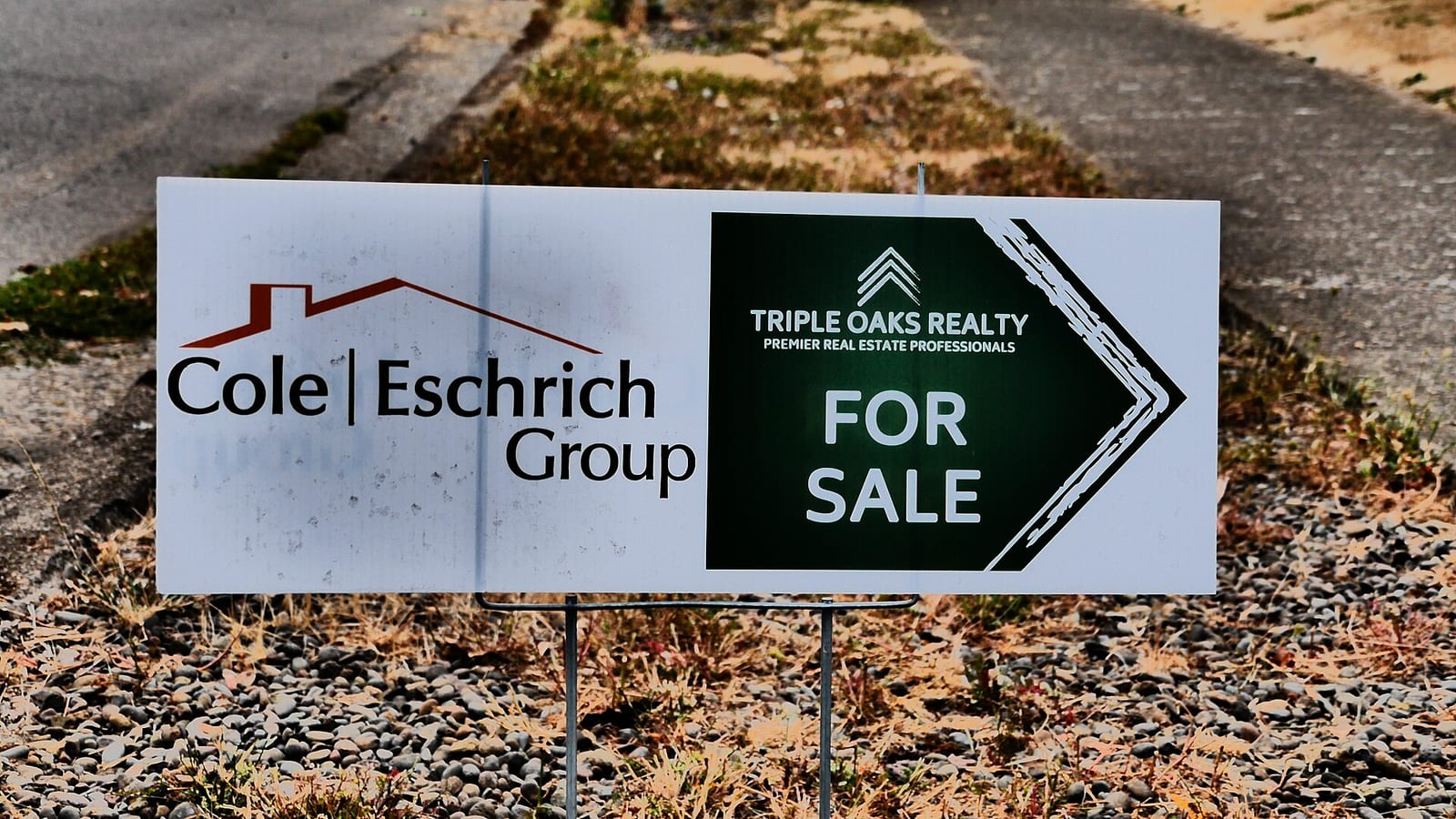 A real estate agent's branded for-sale sign outside a residential listing