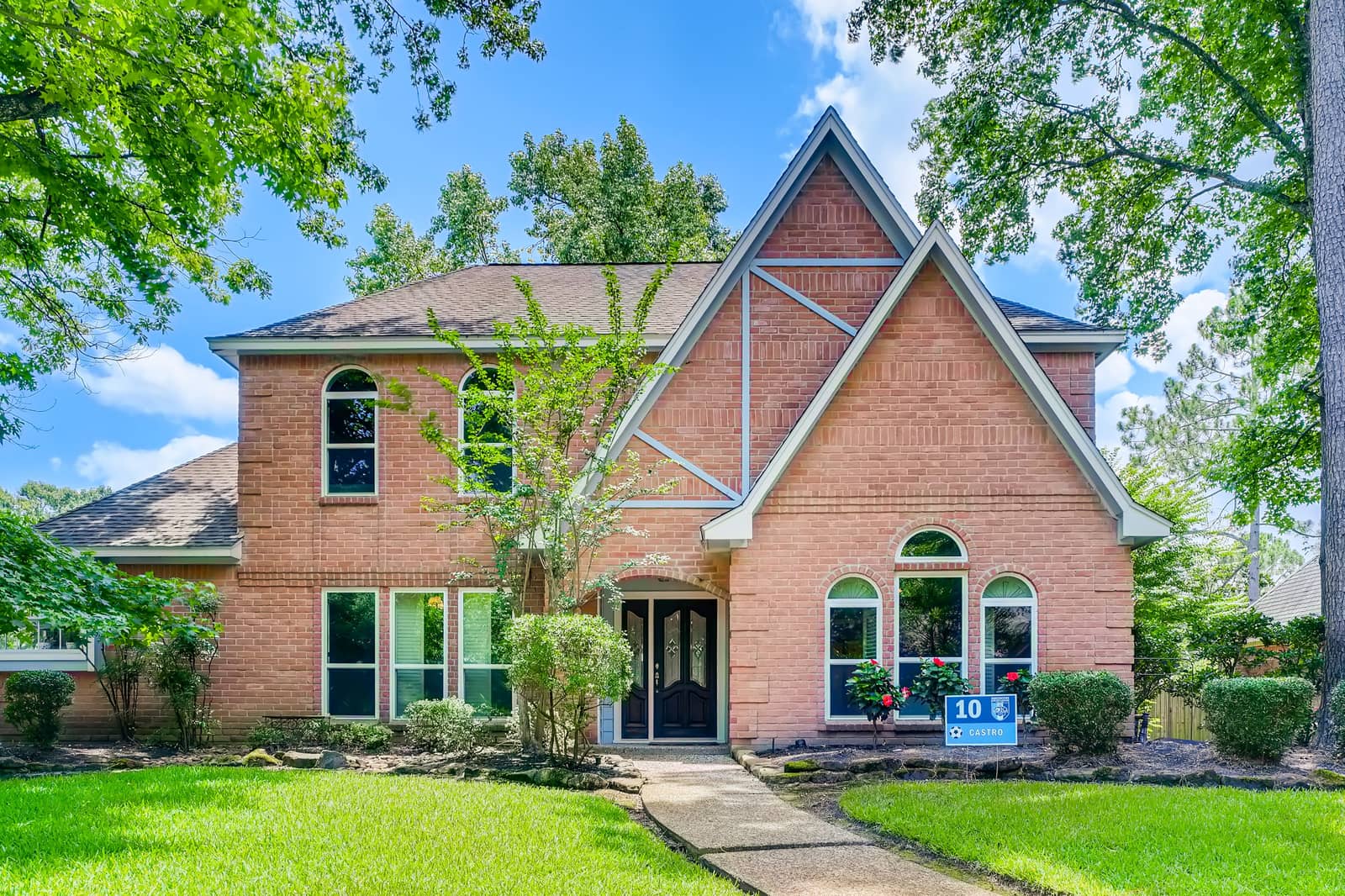 A two-story residential house exterior with a front yard