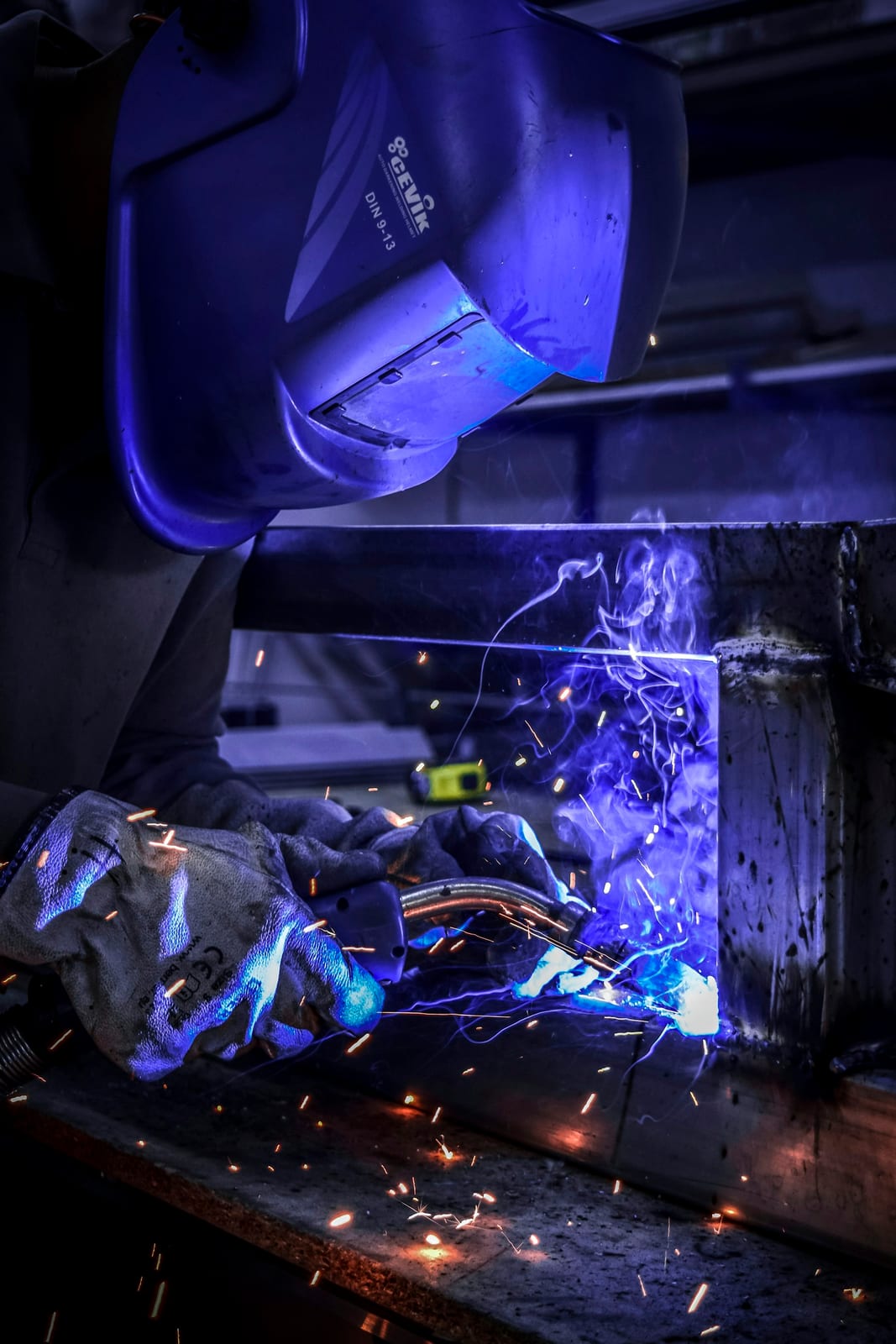 Arc light and blue flash from welding against a welder's protective clothing