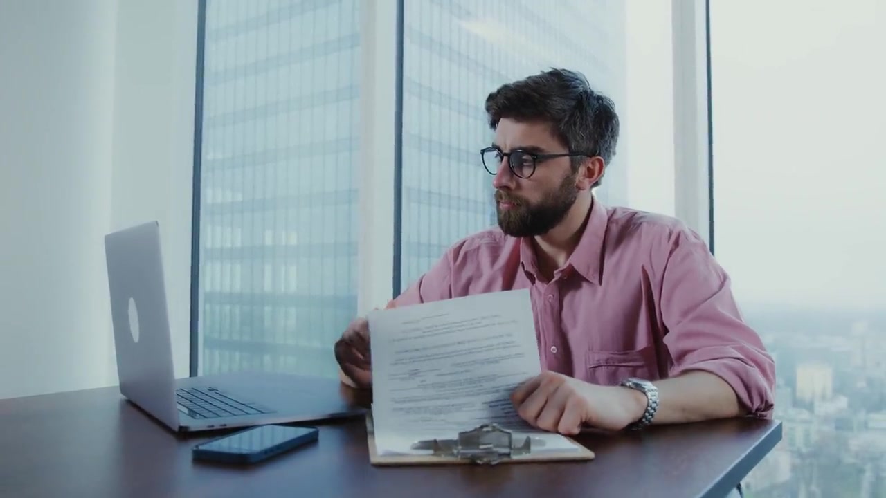 A person at a desk reading through a printed document.
